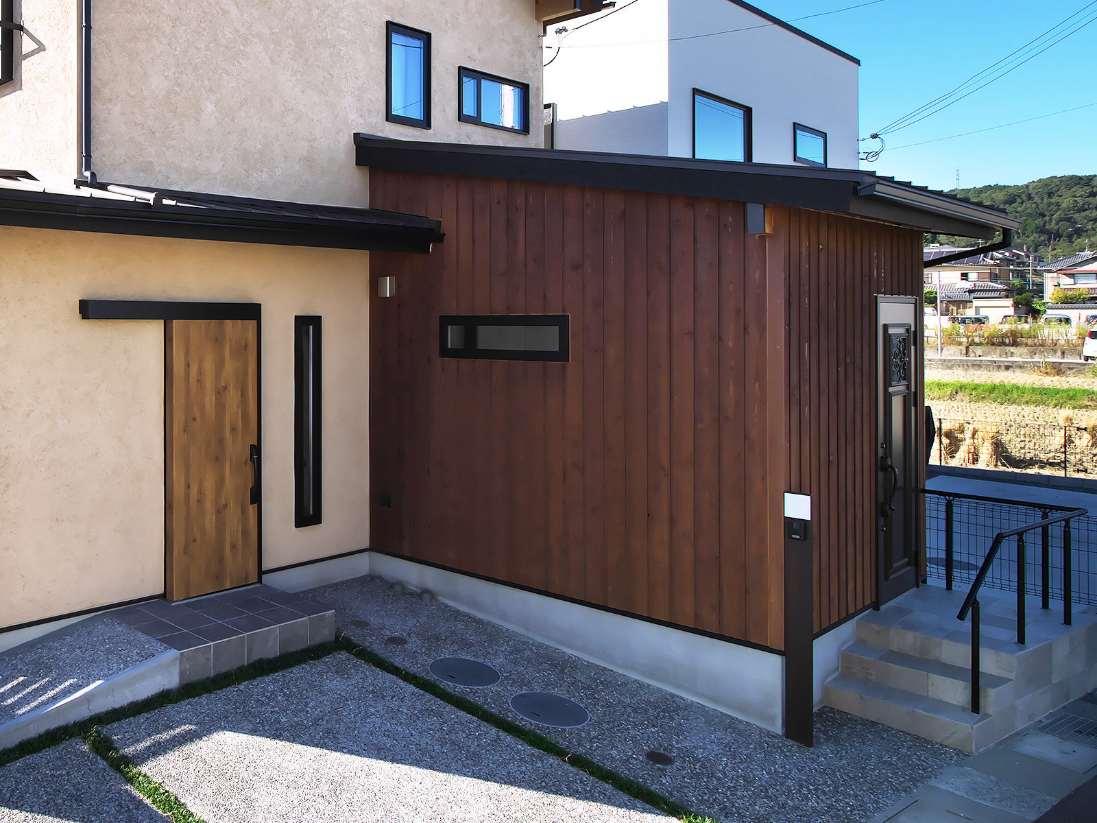 木張り外壁を採用した住宅と店舗併設部分の外観