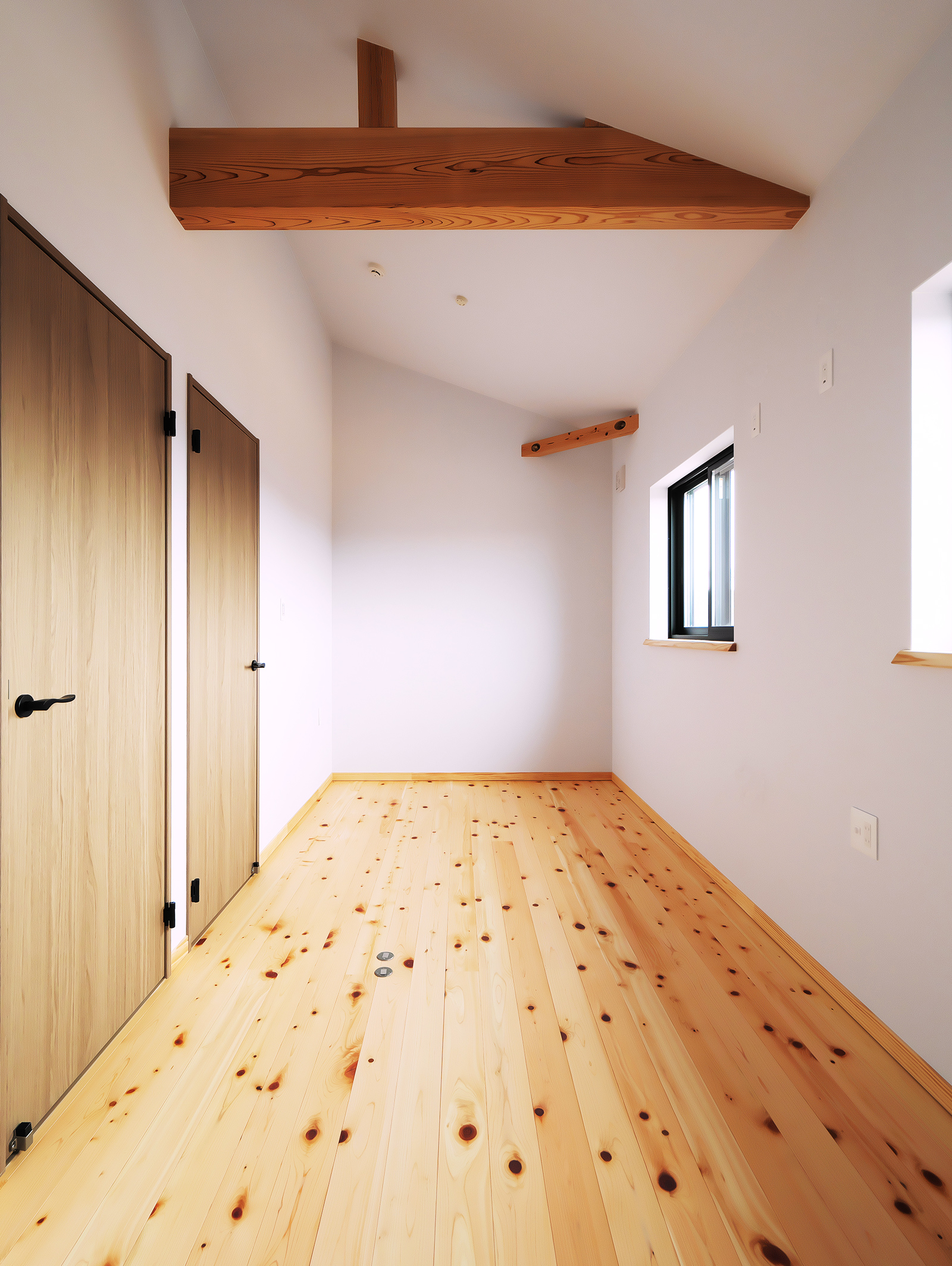 無垢床と化粧梁のあるシンプルな個室空間
